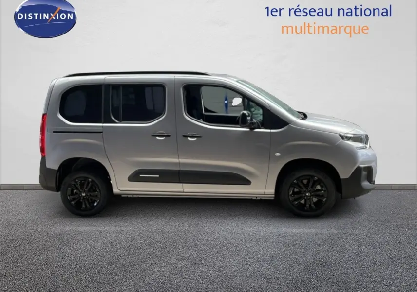 Profil latéral droit du Citroën Berlingo gris Artense métal avec jantes noires et protections latérales noires.