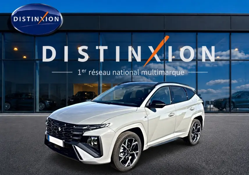 Hyundai Tucson gris shadow en 3/4 avant droit, avec calandre noire et jantes alliage distinctives.