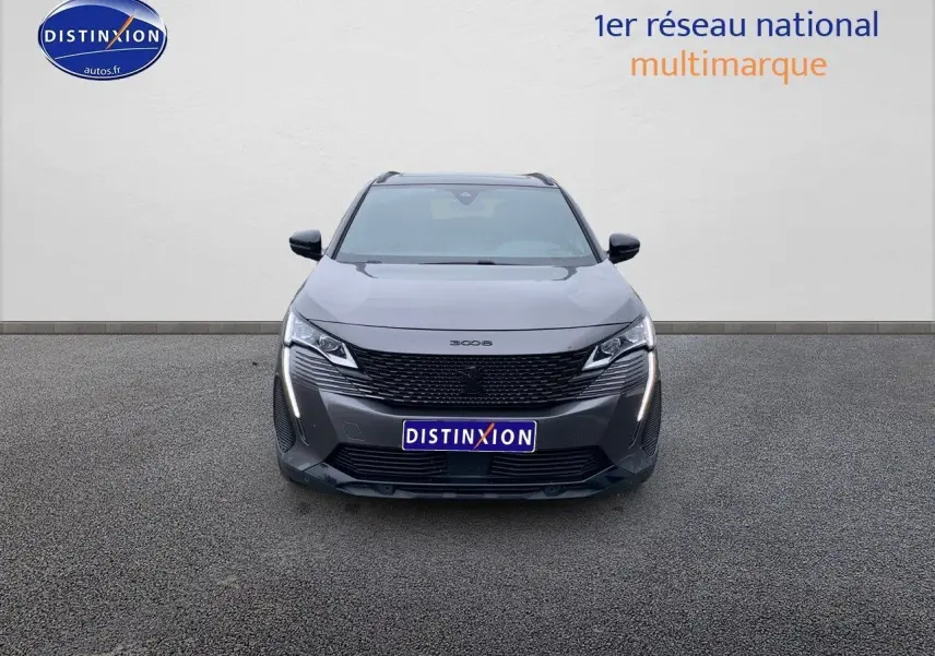 Vue frontale d'un Peugeot 3008 gris platinium métal avec calandre noire et feux LED verticaux allumés.