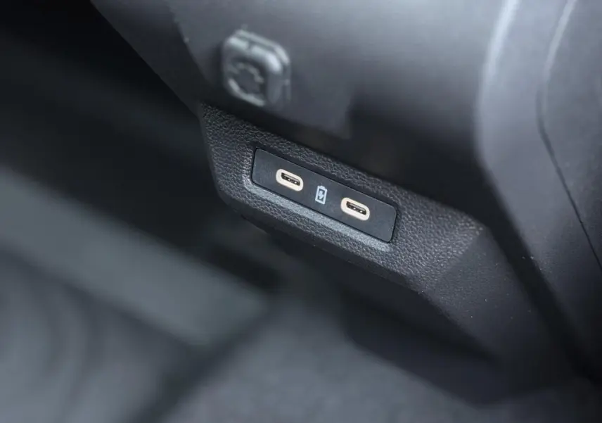 Prise USB double en gros plan dans l'habitacle noir du Dacia Duster TCE 4x2 Mild Hybrid 130 Extrême 2025