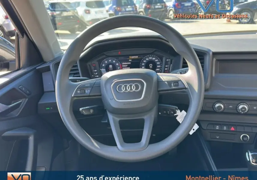 Vue intérieure centrée sur le volant Audi A1 Sportback 30 TFSI 2020 avec tableau de bord numérique et commandes intégrées.