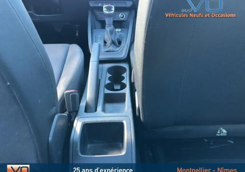Vue intérieure centrée sur la console centrale et levier de vitesse d'une Audi A1 Sportback gris foncé de 2020.