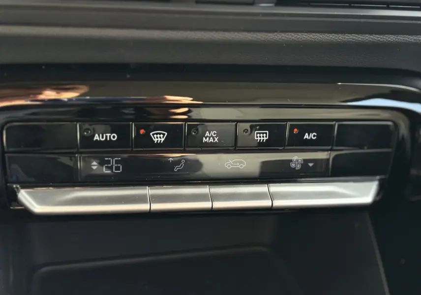 Gros plan sur la commande de climatisation automatique noire du Citroën C3 Aircross Vert Montana, affichant 26°C.