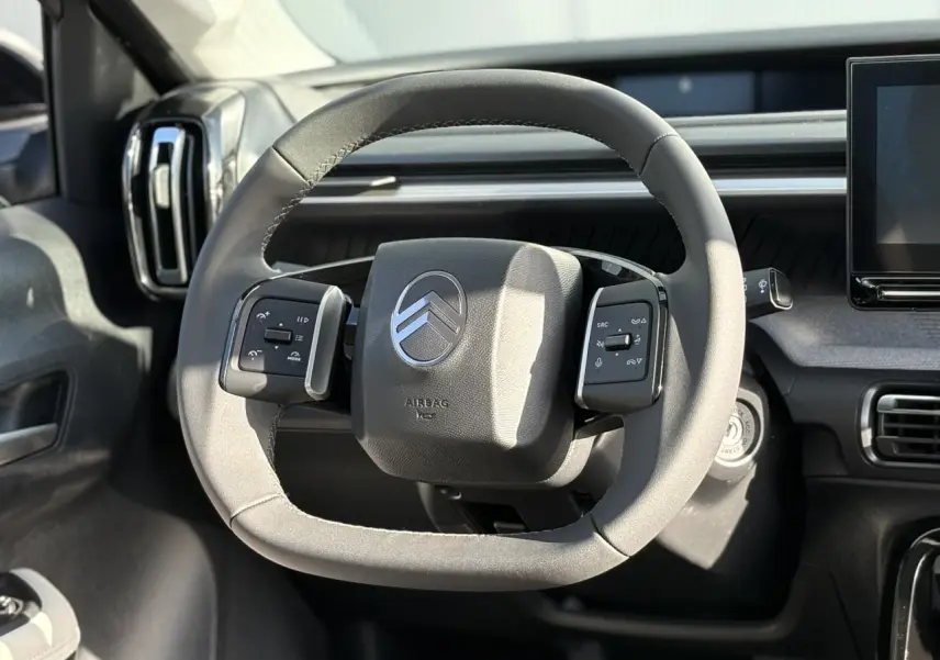 Volant multifonctions noir de Citroën C3 Aircross 2025 vu de face, avec tableau de bord gris et écran tactile à droite.