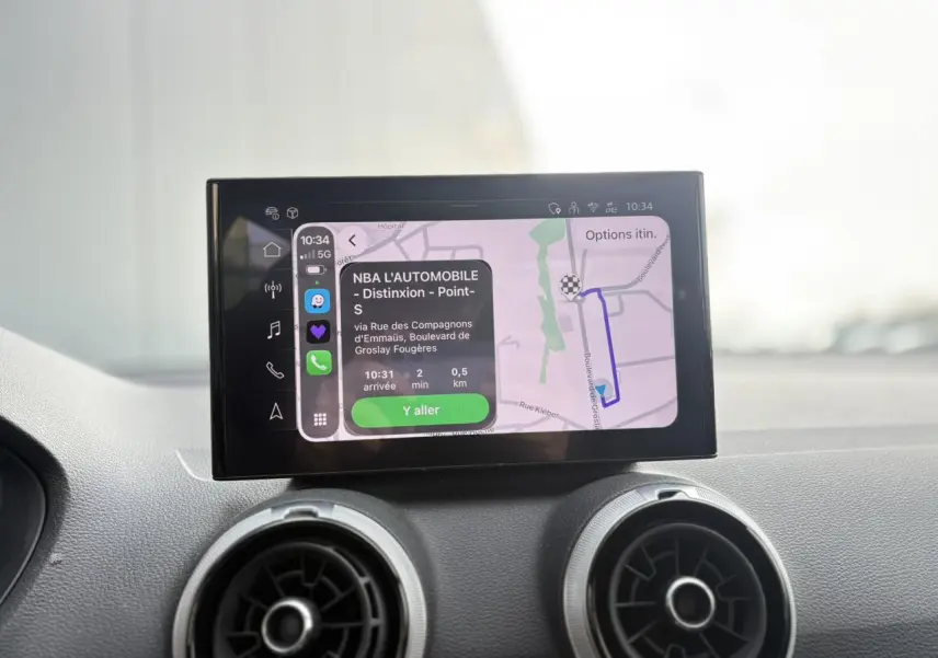 Écran tactile MMI navigation avec carte et itinéraire affichés, intérieur Audi Q2 35 TDI S-Line gris, vue de face rapprochée.