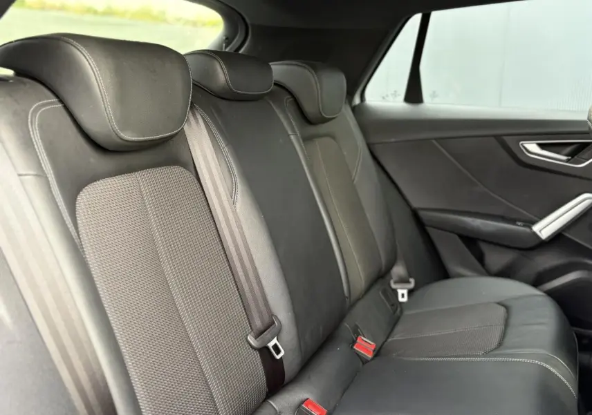 Vue latérale droite des sièges arrière en cuir et tissu gris foncé de l'Audi Q2 35 TDI S-Line 2025.