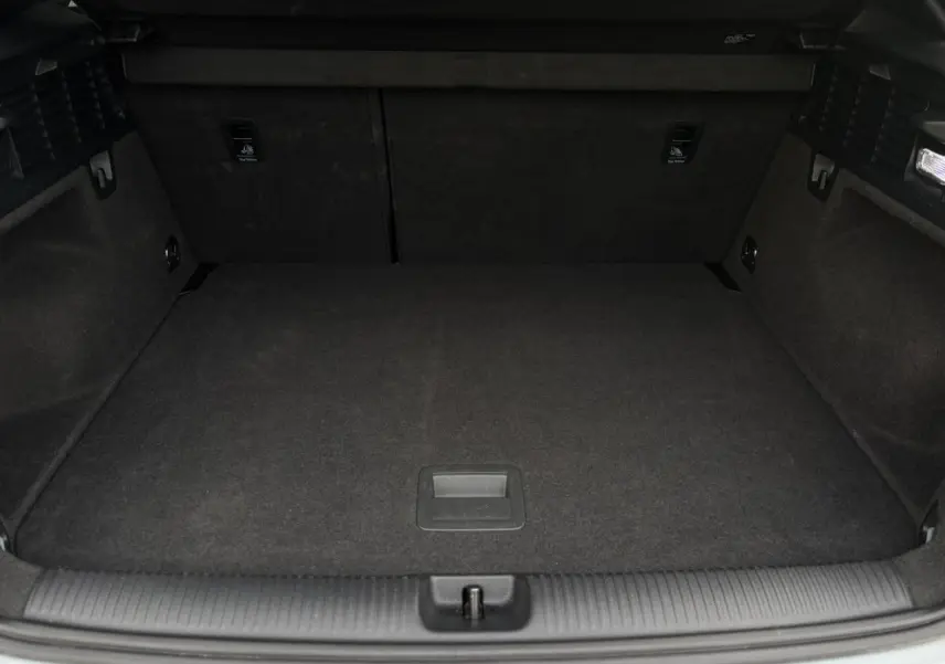 Coffre ouvert vu de l'arrière d'un Audi Q2 35 TDI S-Line gris Flèche, espace de chargement vide et propre.