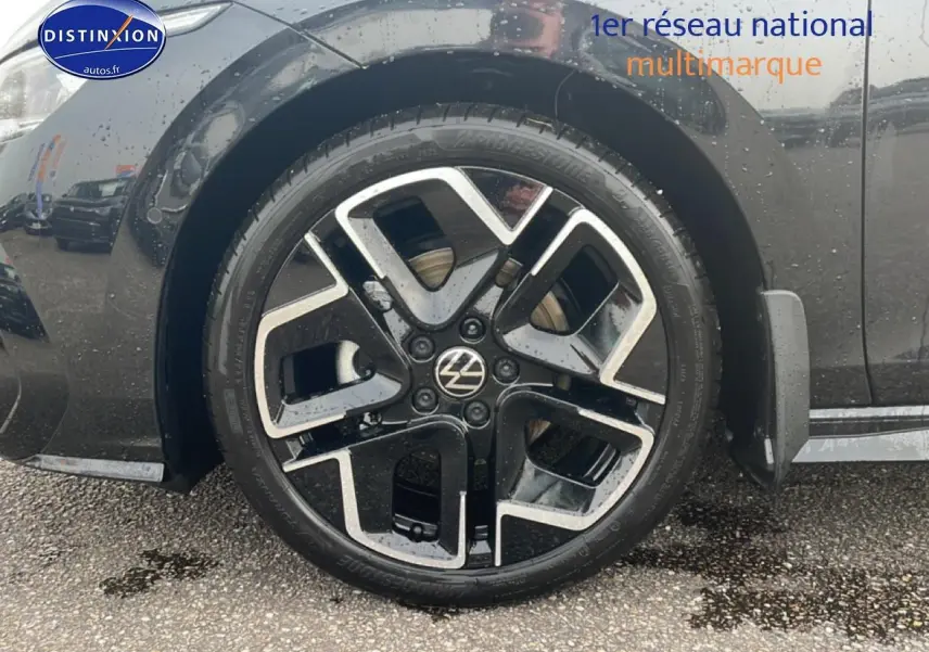 Gros plan sur la roue avant gauche noire d'une Volkswagen Golf 2026 avec jante alu 18 pouces au design moderne.