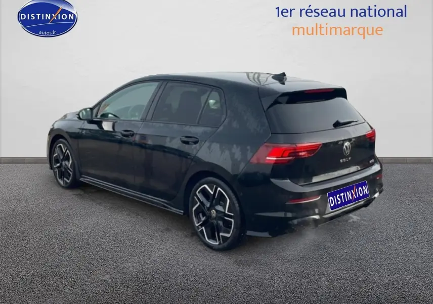 Vue 3/4 arrière droite d'une Volkswagen Golf noire 2026 avec jantes alu distinctives et feux arrière LED.