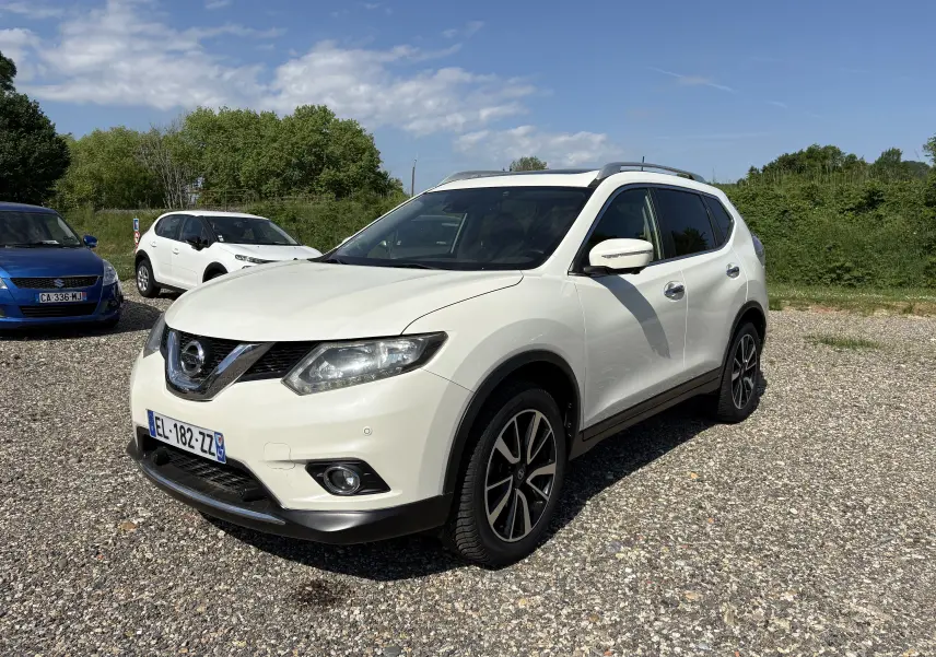 Vue de profil côté gauche d'un Nissan X-Trail 2016 blanc, version White Edition 7 places avec jantes alliage noires.