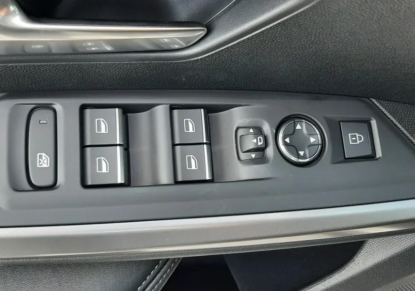 Gros plan sur la commande des vitres et rétroviseurs côté conducteur du Peugeot 3008 gris titane, finition GT.