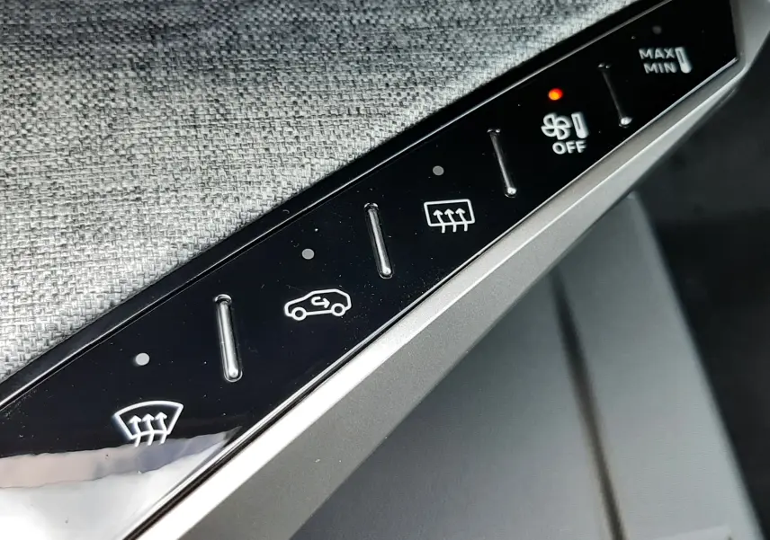 Détail des commandes de climatisation sur la console intérieure du Peugeot 3008 gris titane, avec bouton ventilateur allumé.