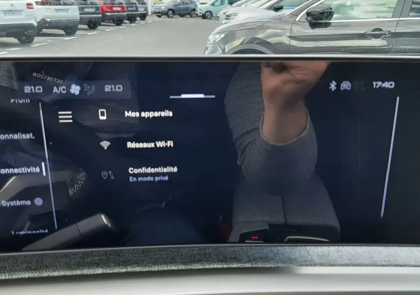 Vue intérieure du tableau de bord numérique du Peugeot 3008 gris titane, affichant les réglages connectivité et Wi-Fi.