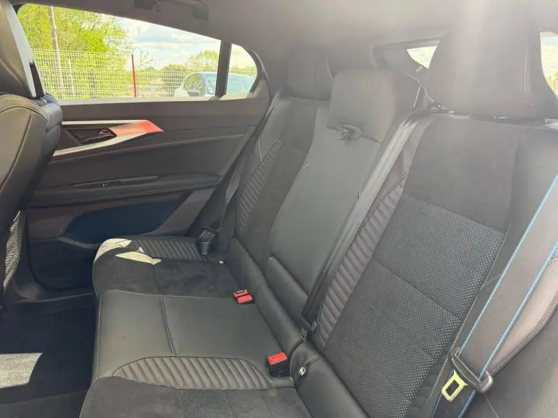 Vue latérale intérieure montrant la banquette arrière en cuir noir étoilé avec surpiqûres bleues du Renault Rafale 2025.