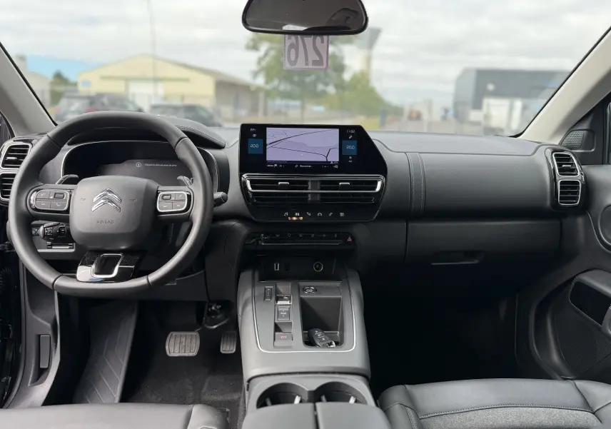 Coffre ouvert vu de l'arrière d'un Citroën C5 Aircross noir perla 2025, avec cache-bagages et intérieur spacieux visible.