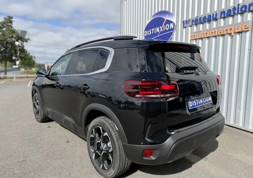 Vue 3/4 arrière droite du Citroën C5 Aircross noir perla, soulignant ses feux arrière LED et ses jantes noires distinctives.