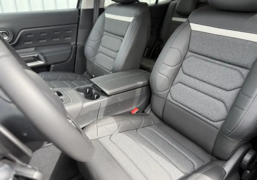 Vue intérieure côté conducteur du tableau de bord et console centrale du Citroën C5 Aircross noir Perla avec écran tactile et commandes modernes.