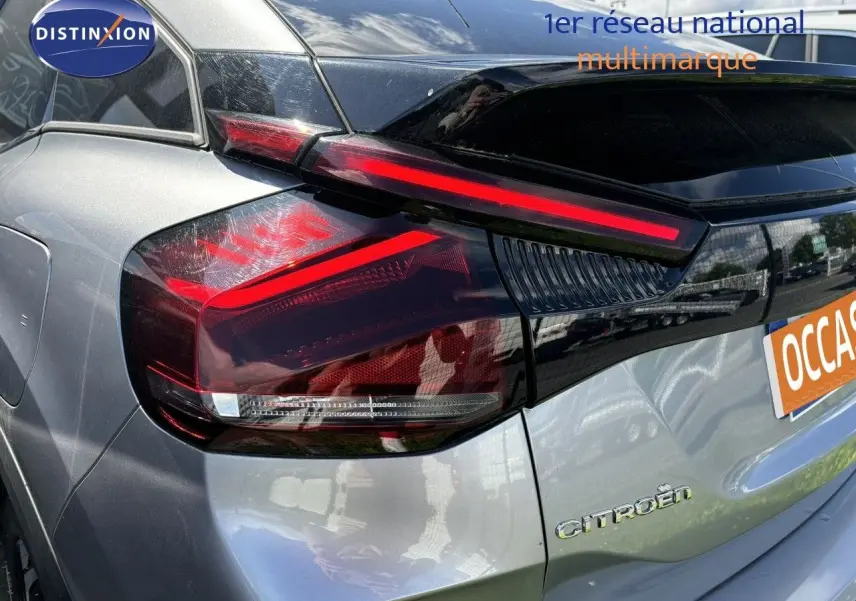 Vue 3/4 arrière droite d'une Citroën C4 PureTech 130 Shine gris Artense avec feux arrière LED distinctifs.