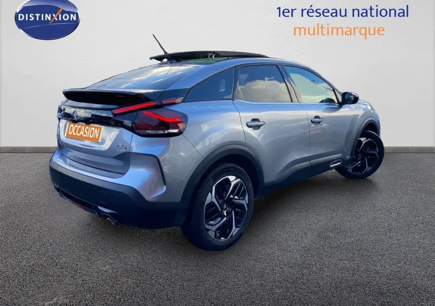 Vue 3/4 arrière droite d'une Citroën C4 PureTech 130 Shine gris Artense avec jantes noires bicolores.