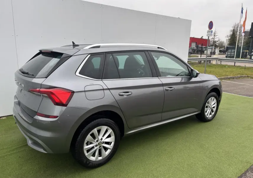 Vue 3/4 arrière droite d'un Skoda Kamiq gris graphite métallisé avec jantes alliage 17 pouces sur parking.