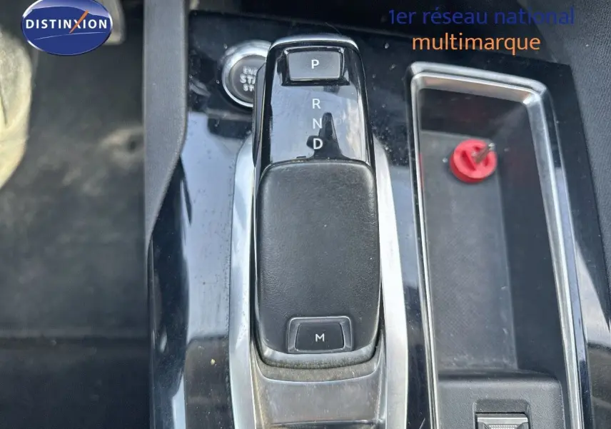 Le levier de vitesses automatique noir du Peugeot 3008 2022, avec console centrale brillante et rangement latéral.