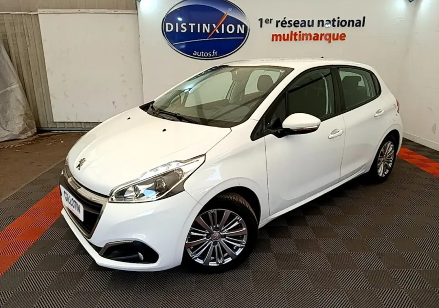 Peugeot 208 Puretech 82 Signature blanc vue 3/4 avant droit dans un showroom avec sol à damier noir et rouge.