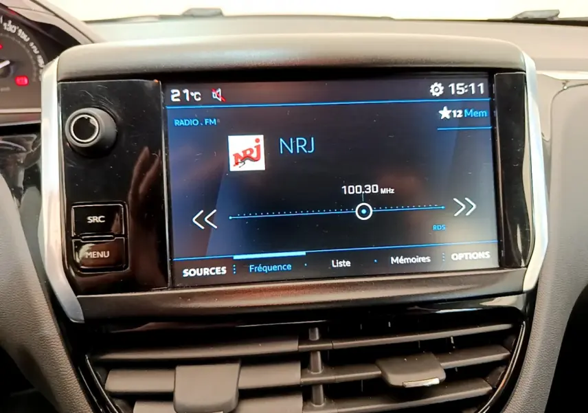 Écran tactile central affichant la radio NRJ dans l'habitacle d'une Peugeot 208 Puretech 82 Signature 2019.