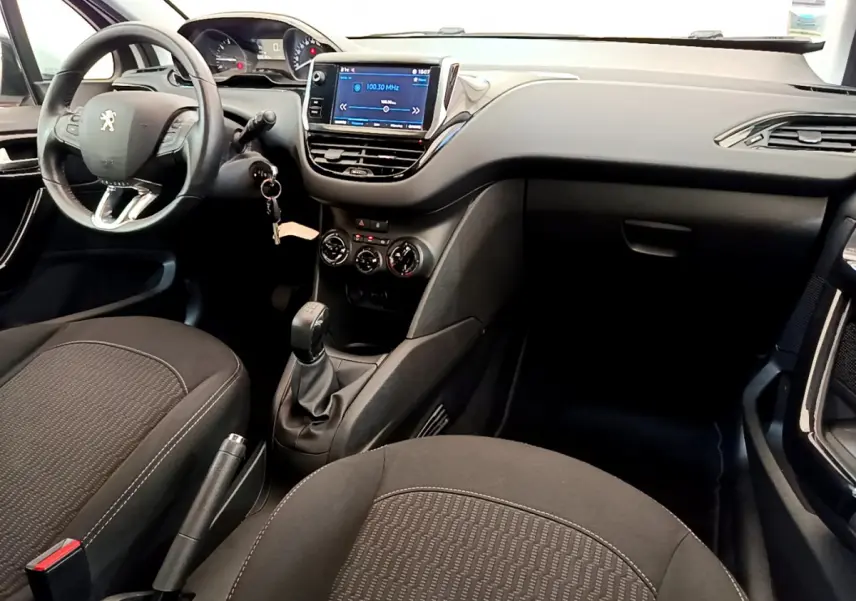 Intérieur de la Peugeot 208 Puretech 82 Signature 2019, vue du poste de conduite avec volant cuir et écran tactile central.