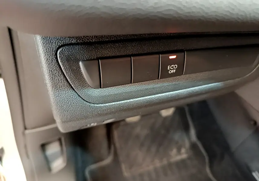 Bouton ECO OFF allumé sur la console inférieure côté conducteur de la Peugeot 208 Puretech 82 Signature blanche 2019.