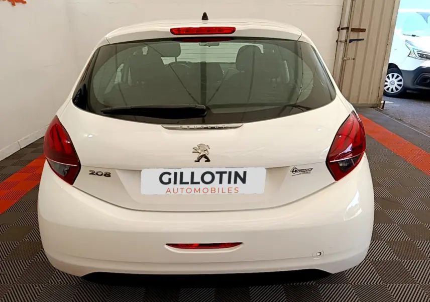 Vue arrière d'une Peugeot 208 Puretech 82 Signature blanche, avec feux rouges et logo lion visible.
