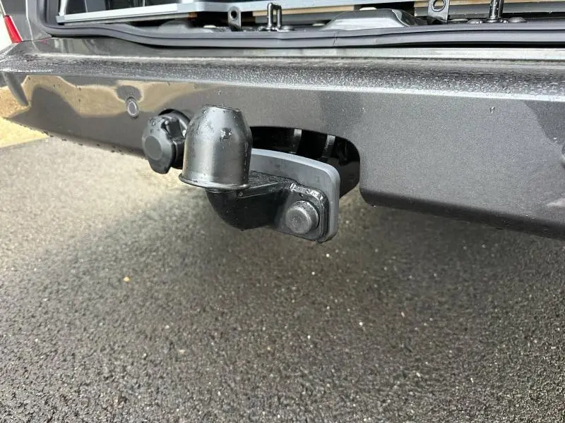 Gros plan sur l'attelage d'un Volkswagen Transporter Procab gris, fixé sous le pare-chocs arrière.
