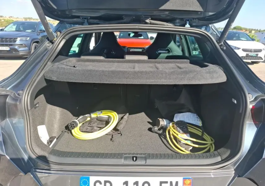 Coffre ouvert vu de l'arrière d'un CUPRA Formentor gris 2023 avec câbles de recharge hybride visibles.