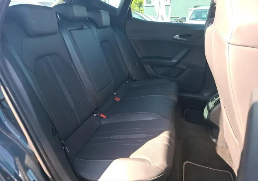 Vue intérieure côté gauche des sièges arrière en cuir noir du CUPRA Formentor gris avec finitions modernes et ceintures visibles.