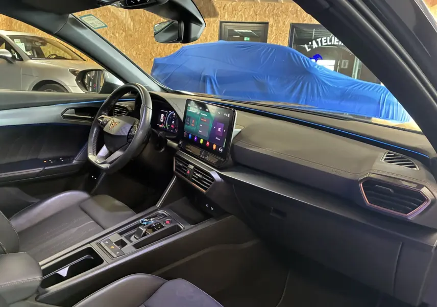 Intérieur de la CUPRA Formentor 1.4 e-Hybrid 2023 vu côté passager, avec volant cuir et écran tactile central.