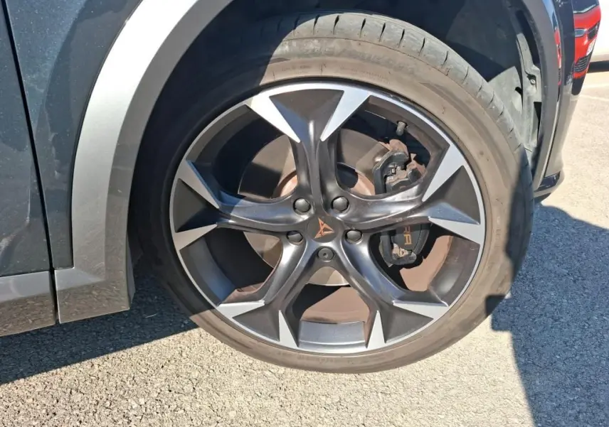 Gros plan sur la roue avant gauche du CUPRA Formentor gris 2023 avec jante alliage noire et logo CUPRA orange.