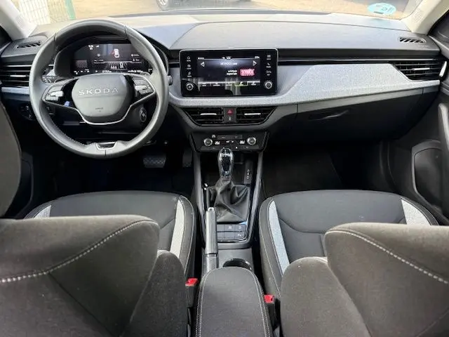 Intérieur de la Skoda Scala 2025 en gris graphite, vue avant centrée sur le tableau de bord et volant multifonction.