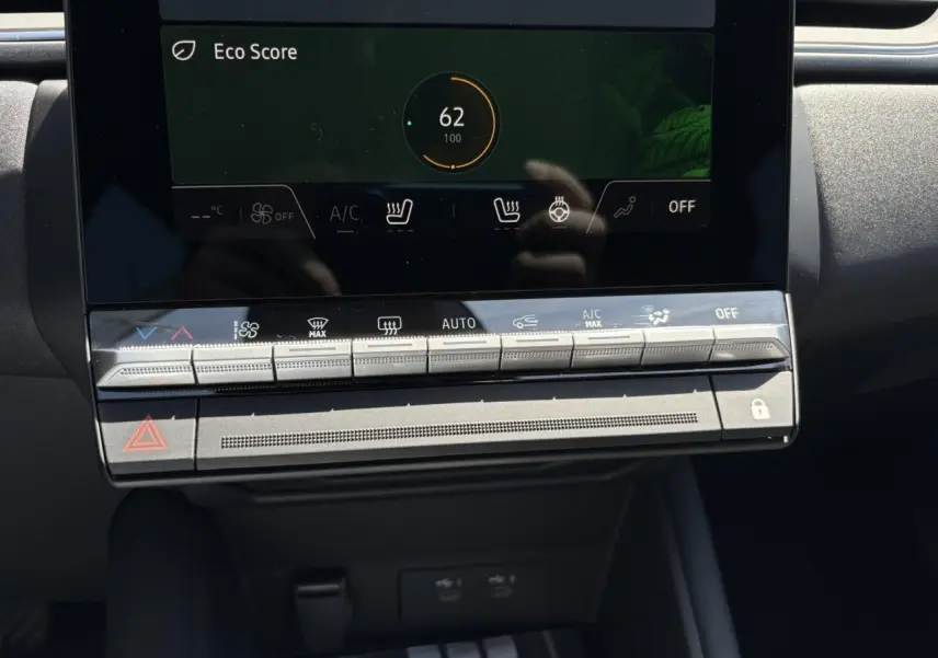 Gros plan sur la console centrale tactile du Renault Captur noir étoile 2025, affichant l'Eco Score et commandes climatisation.
