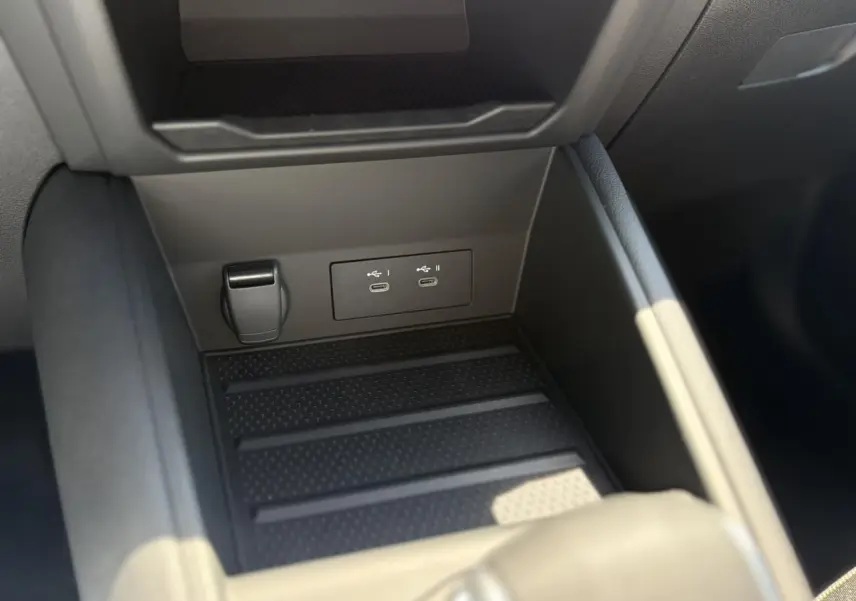 Gros plan sur la console centrale noire du Renault Captur 2025, montrant les ports USB-C doubles et un allume-cigare.