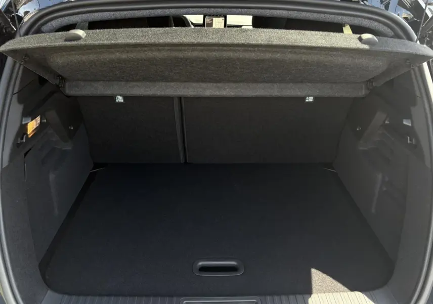 Coffre ouvert vu de l'arrière du Renault Captur noir Étoile, montrant l'espace de chargement vide et la tablette cache-bagages.