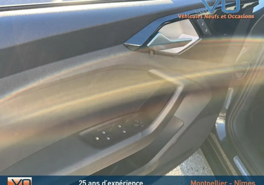 Intérieur côté conducteur de l'Audi A1 Sportback gris foncé, mettant en valeur la portière avec commandes des vitres électriques.