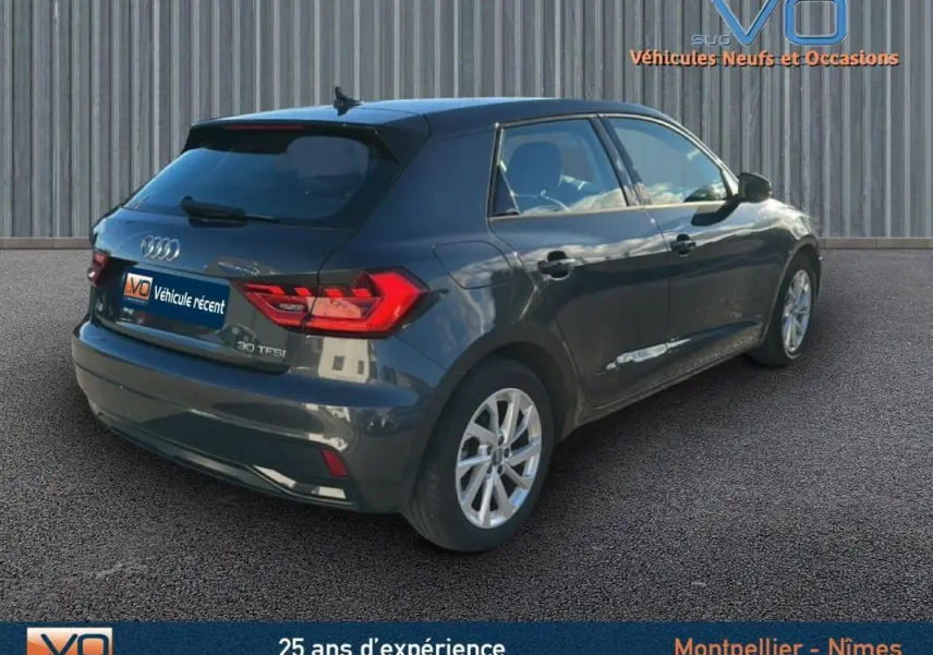 Vue 3/4 arrière droite d'une Audi A1 Sportback gris foncé de 2019 avec jantes 16 pouces et vitres surteintées.