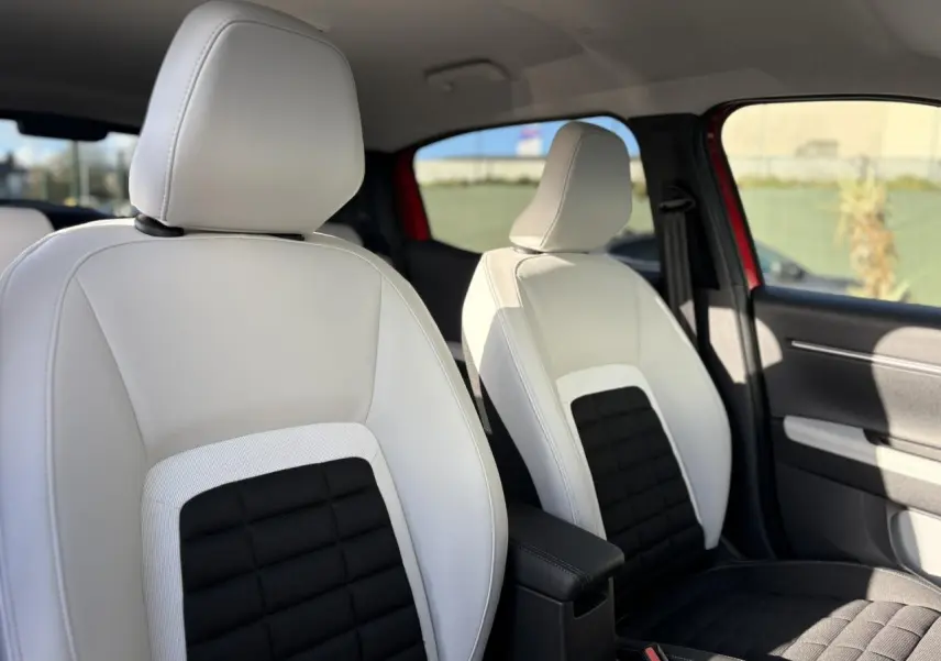Vue intérieure sur les sièges avant bicolores blanc et noir du Citroën C3 Aircross Hybrid 2025, avec accoudoir central.