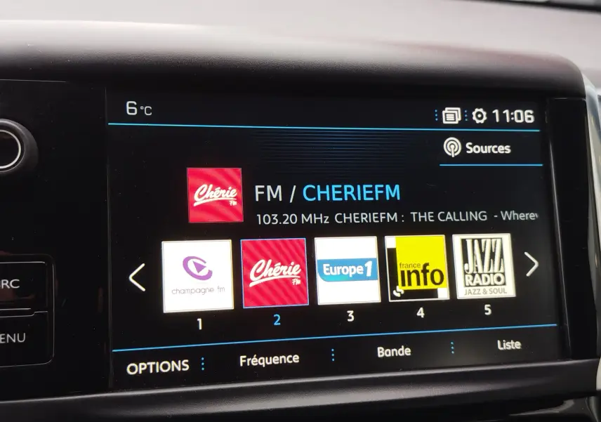 Écran tactile central de la Peugeot 208 noir, affichant les stations radio FM avec interface moderne et lisible.