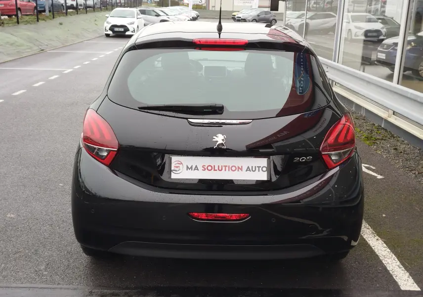 Vue arrière d'une Peugeot 208 noire Perla Nera de 2019, avec feux arrière distinctifs et plaque d'immatriculation "Ma Solution Auto".