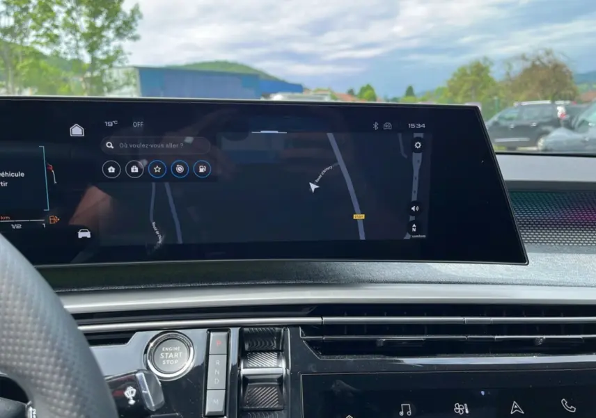 Vue intérieure du tableau de bord du Peugeot 5008 Hybrid 2025 avec écran tactile de navigation et commandes centrales.