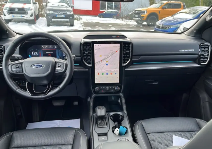 Vue intérieure avant du Ford Ranger 2026 gris iconic, tableau de bord moderne avec écran tactile vertical et volant cuir multifonctions.