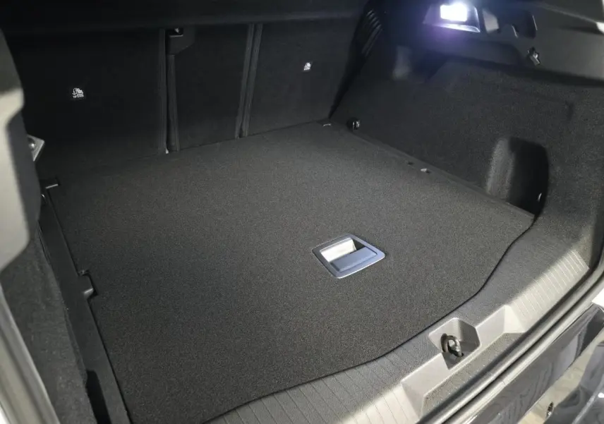 Coffre ouvert vu de l'arrière du Citroën C5 Aircross blanc, montrant un espace de chargement plat et noir.