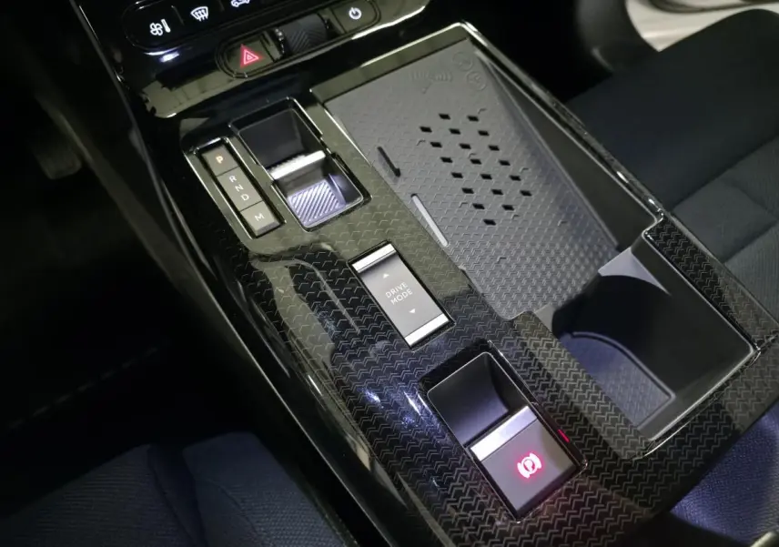 Vue rapprochée de la console centrale noire en carbone du Citroën C5 Aircross hybride avec sélecteur de boîte auto et bouton Drive Mode.