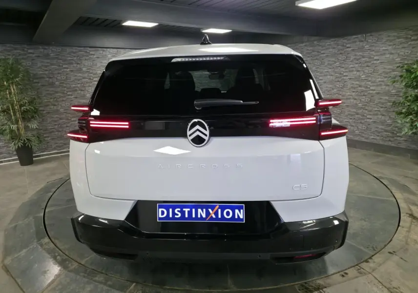 Vue arrière d'un Citroën C5 Aircross blanc avec feux arrière LED horizontaux et logo central noir brillant.