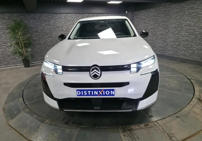 Vue avant d'un Citroën C5 Aircross blanc 2026 avec calandre noire et phares LED allumés en intérieur.